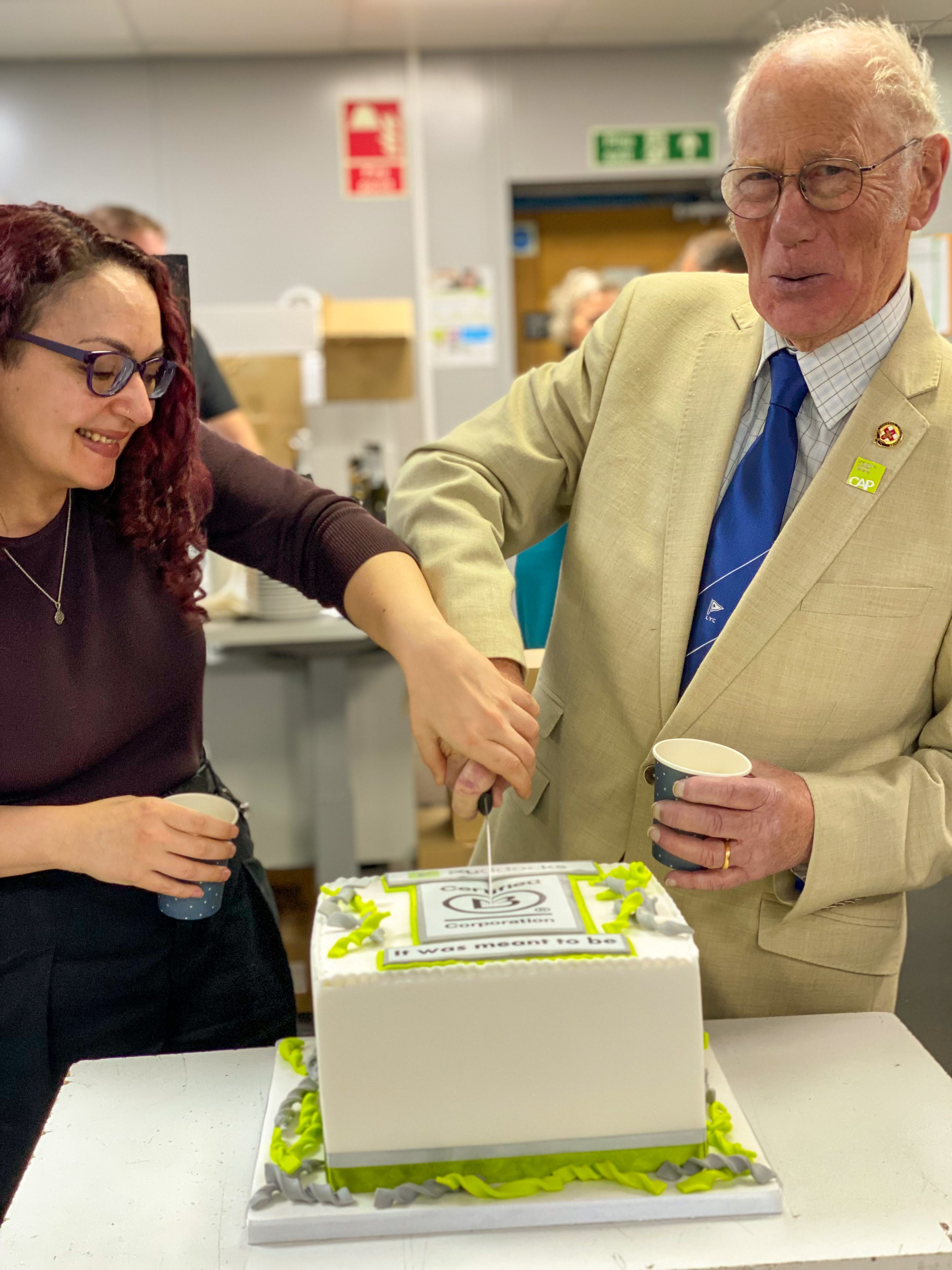 Henry Ruddock & Zarah Torrington cutting the B Corp cake
