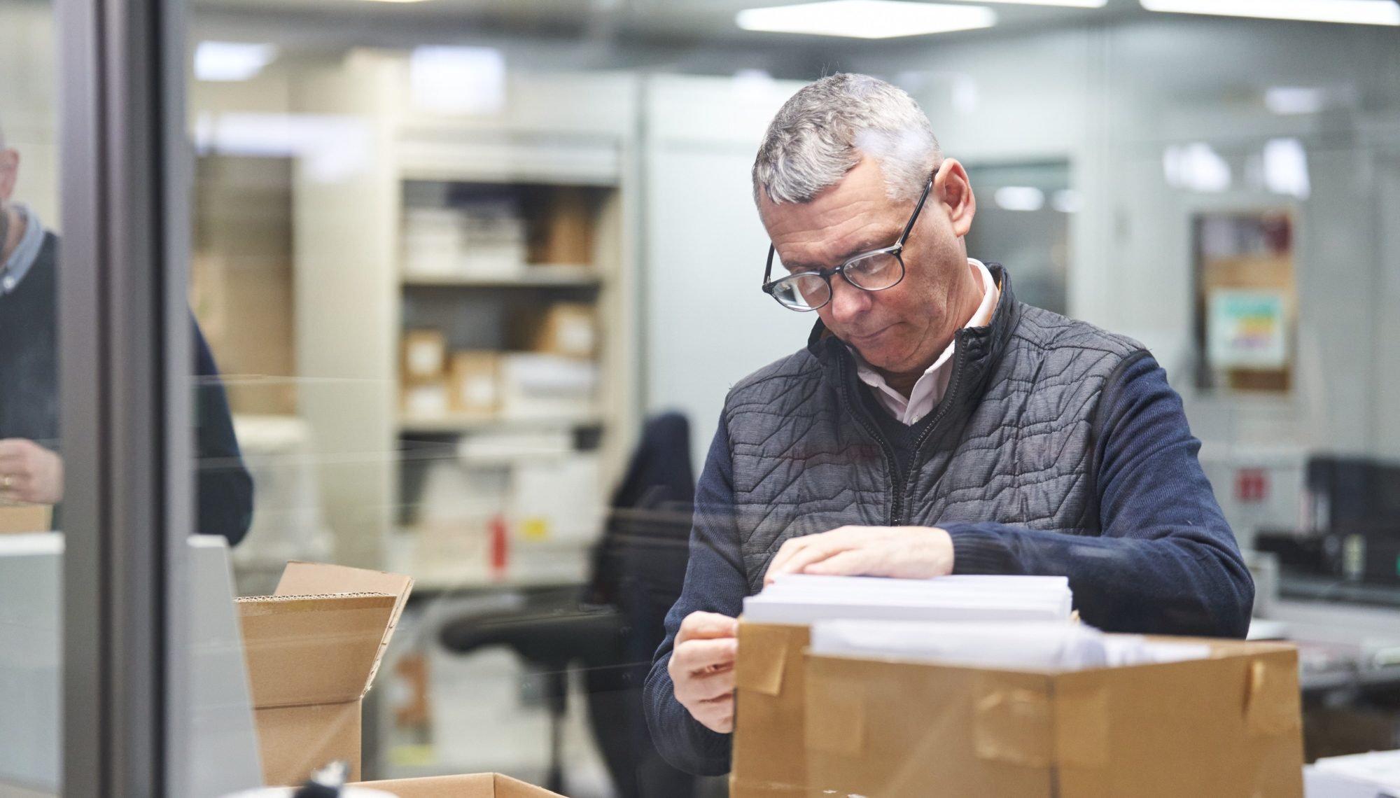 how to manage rising postal costs. Image of Ady Potter handling direct mail in the Ruddocks warehouse