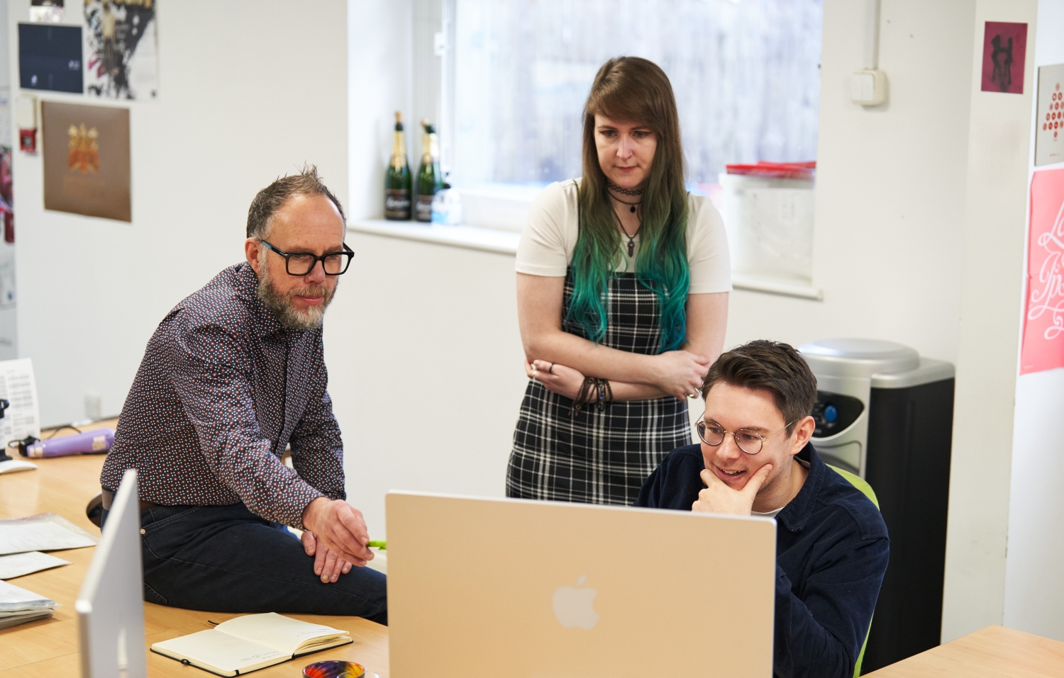 a team sitting around a computer